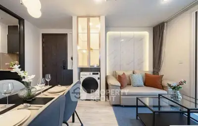 Modern living room with dining area and washing machine, featuring elegant decor and cozy seating.