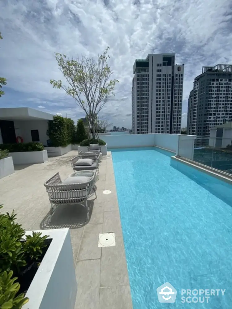 Luxurious rooftop pool with city skyline view and modern lounge chairs