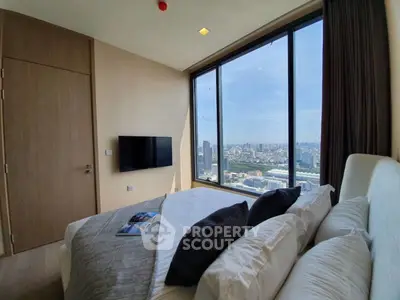 Luxurious bedroom with stunning city view from floor-to-ceiling windows.