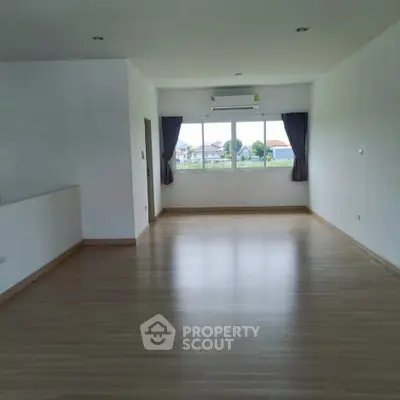 Spacious empty living room with large window and wooden flooring, perfect for customization.