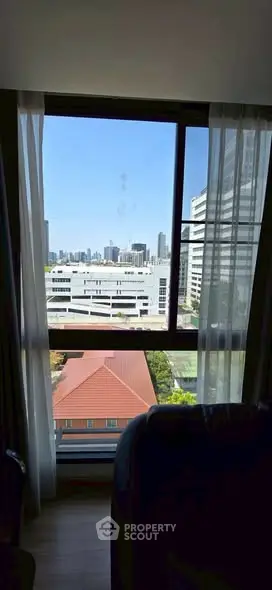 Stunning cityscape view from a modern apartment window, showcasing urban skyline.