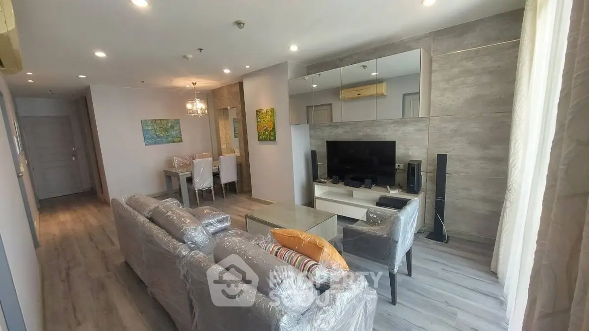 Modern living room with stylish decor and dining area in open layout apartment.