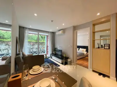 Modern open-plan living room with elegant dining area and view of cozy bedroom, featuring stylish decor and natural light.