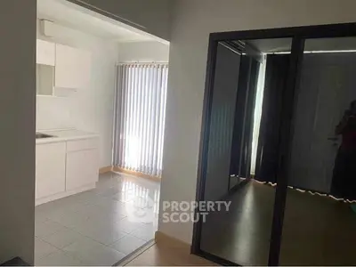 Modern apartment interior with sleek kitchen and mirrored closet doors.