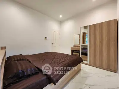 Spacious bedroom with modern furnishings and elegant decor, featuring a comfortable bed and stylish wardrobe.