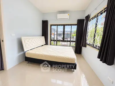 Spacious bedroom with large windows and modern air conditioning unit