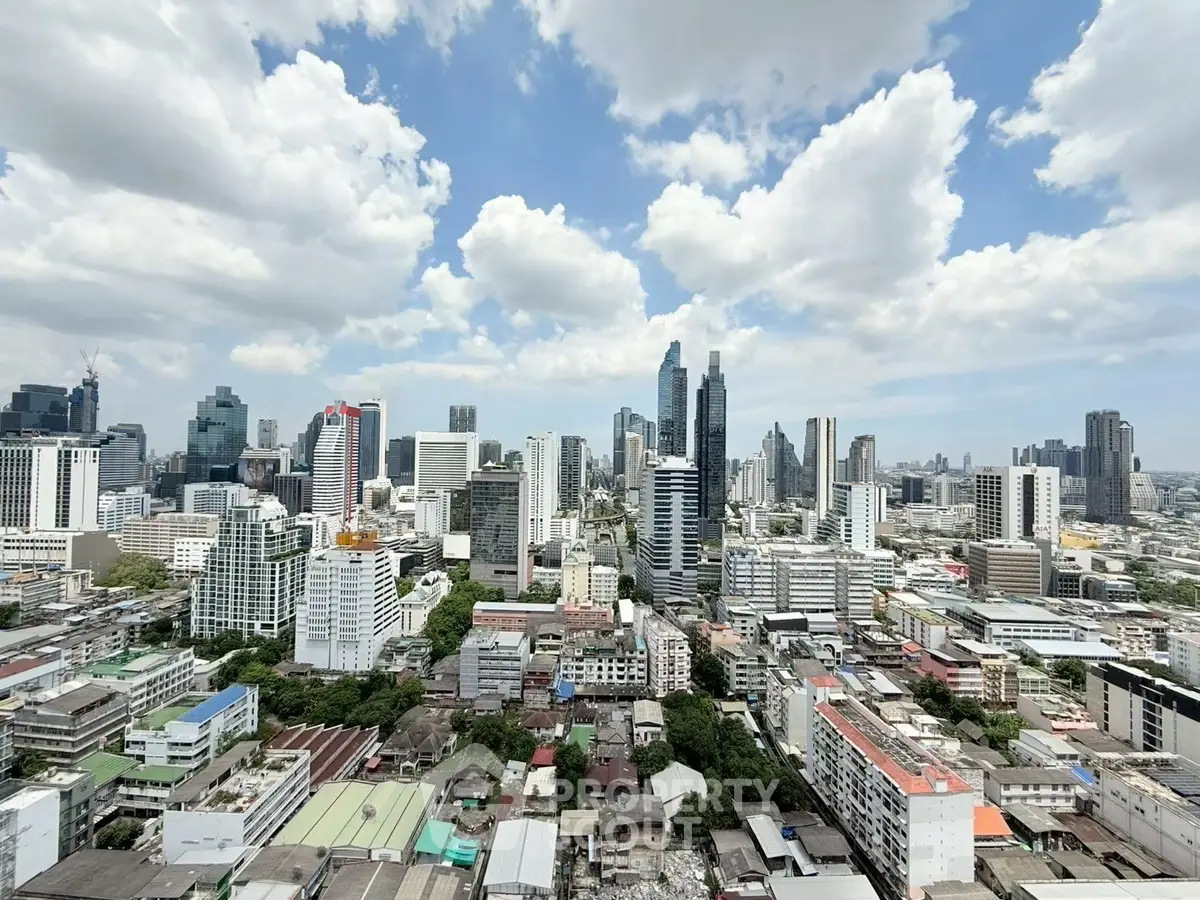 Stunning cityscape view showcasing modern skyscrapers under a vibrant blue sky with fluffy clouds.