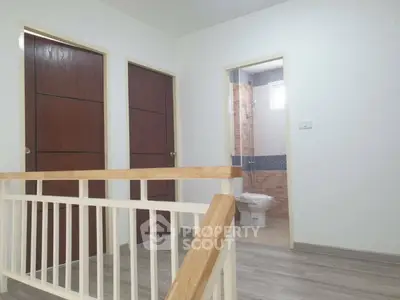 Spacious hallway with wooden doors and bathroom access, ideal for modern living.