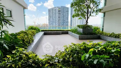 Spacious balcony with lush greenery and city skyline view