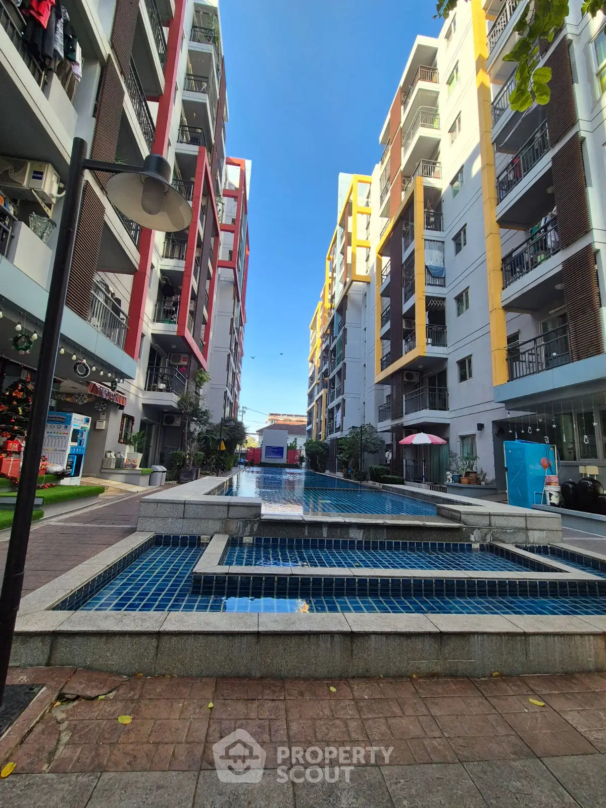 Modern apartment complex with central pool and vibrant architecture