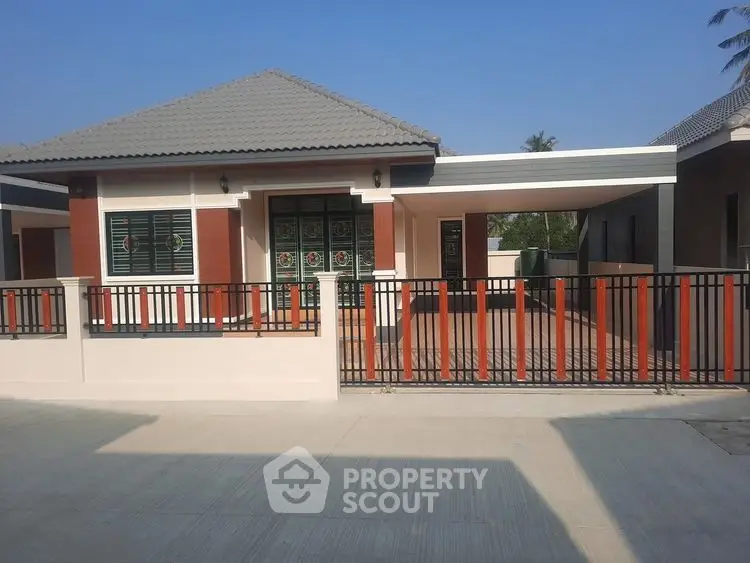 Modern single-story house with gated entrance and spacious driveway.