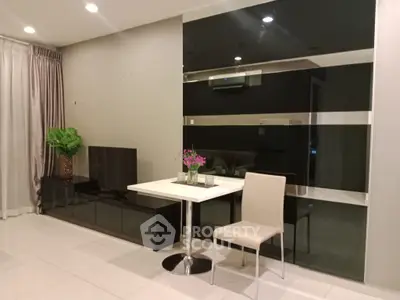 Modern living room with sleek furniture and stylish decor, featuring a TV unit and elegant dining setup.