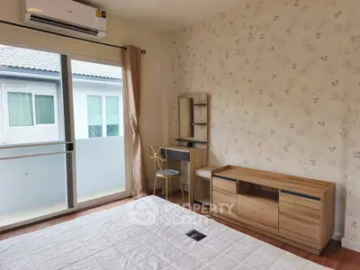 Cozy bedroom with elegant wallpaper and sliding glass door to balcony