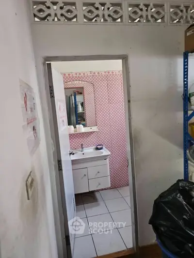 Charming bathroom with pink polka dot wallpaper and white vanity unit, perfect for a cozy home.