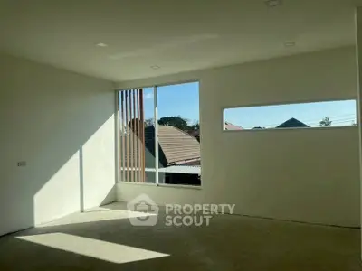 Spacious empty room with large windows offering natural light and scenic views, ideal for customization.