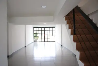 Spacious modern living room with large windows and elegant staircase