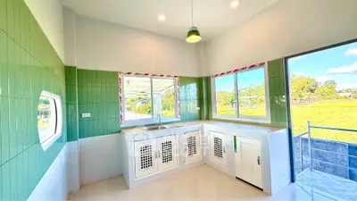 Bright modern kitchen with green tiles and scenic view