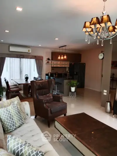 Spacious living room with elegant chandelier and open kitchen layout