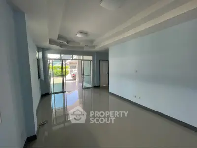 Spacious modern living room with large windows and sleek tile flooring