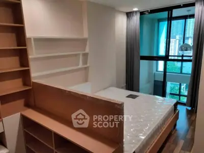 Modern bedroom with large window and built-in shelving in urban apartment