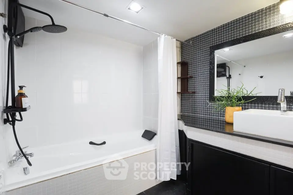 Modern bathroom with sleek black and white design, featuring a bathtub and stylish fixtures.