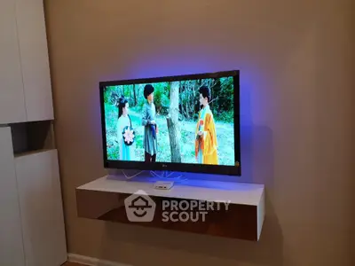 Modern living room with wall-mounted TV and sleek floating shelf