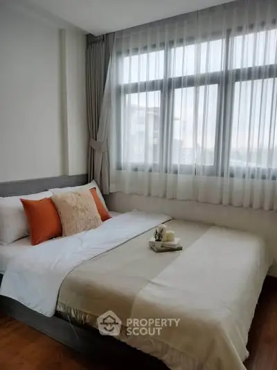 Cozy bedroom with large window and stylish decor in modern apartment