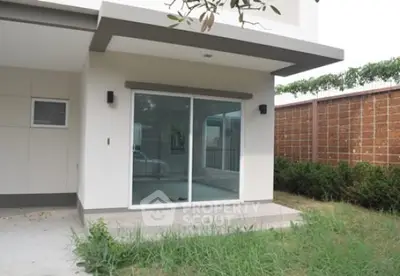 Modern exterior with sliding glass doors and small garden area.