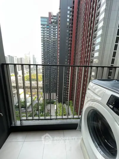 Modern balcony with washing machine and cityscape view in high-rise apartment.