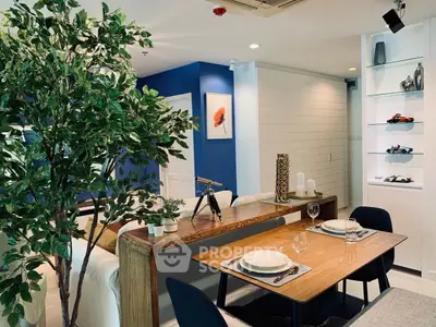 Stylish modern living room with dining area, featuring elegant decor and vibrant blue accent wall.