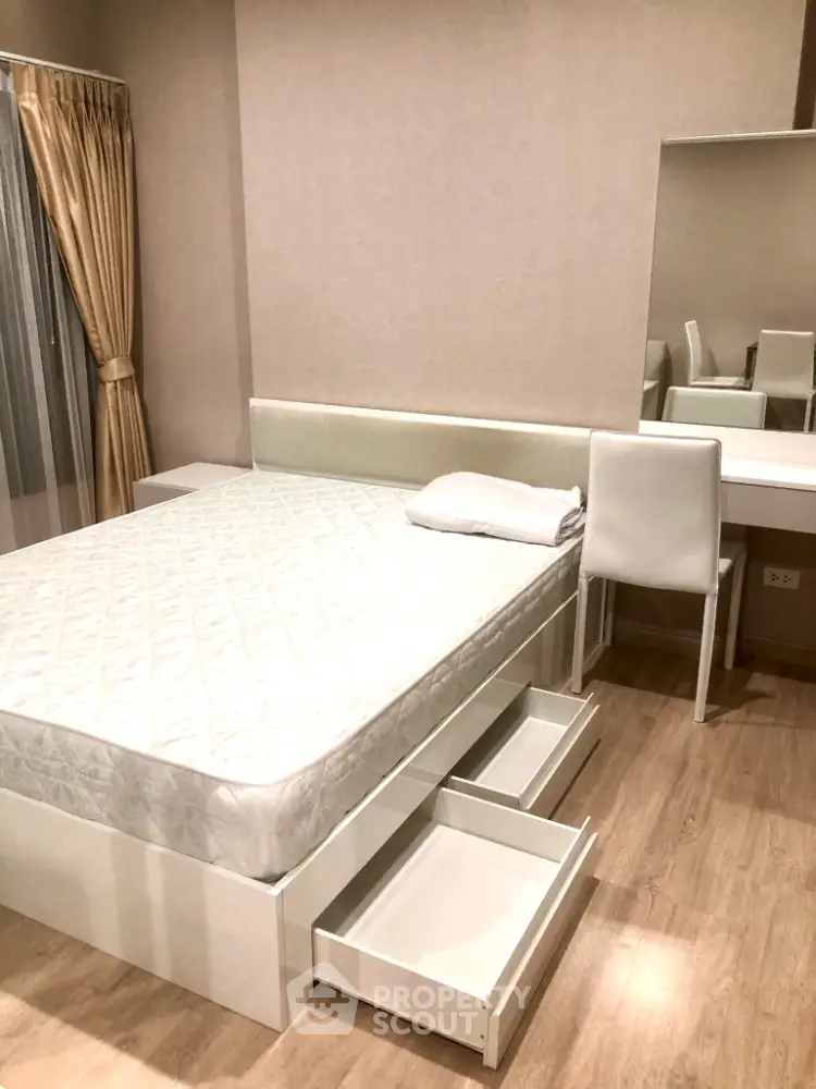 Modern bedroom with sleek furniture and built-in storage drawers in a stylish apartment.