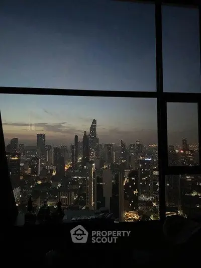 Stunning cityscape view from high-rise window at dusk, showcasing vibrant skyline and twinkling city lights.
