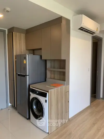 Modern kitchen with integrated washing machine and sleek cabinetry in a stylish apartment.