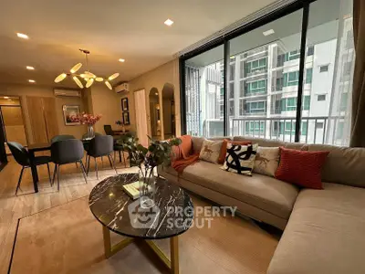 Modern living room with stylish decor and large windows offering city views.