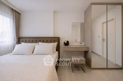 Elegant bedroom with plush bed, mirrored wardrobe, and natural light from large window.