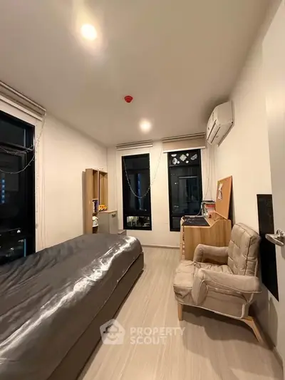 Cozy bedroom with modern decor and large windows in a stylish apartment.