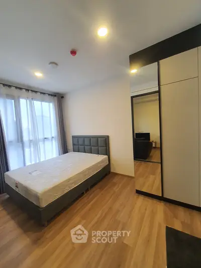 Spacious bedroom with modern design and large window for natural light.