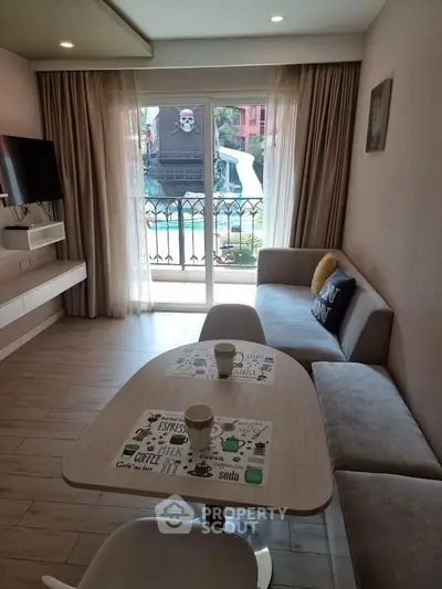 Charming living room with balcony view, modern decor, and cozy seating area.