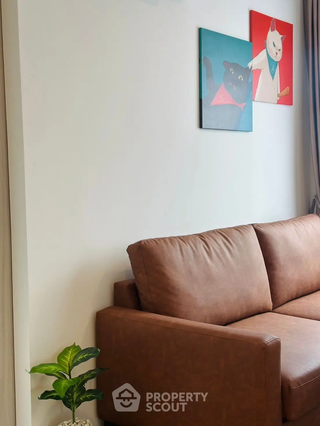 Stylish living room with brown leather sofa and cat-themed wall art