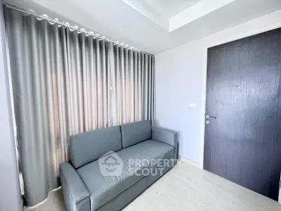 Modern living room with sleek gray sofa and elegant curtains