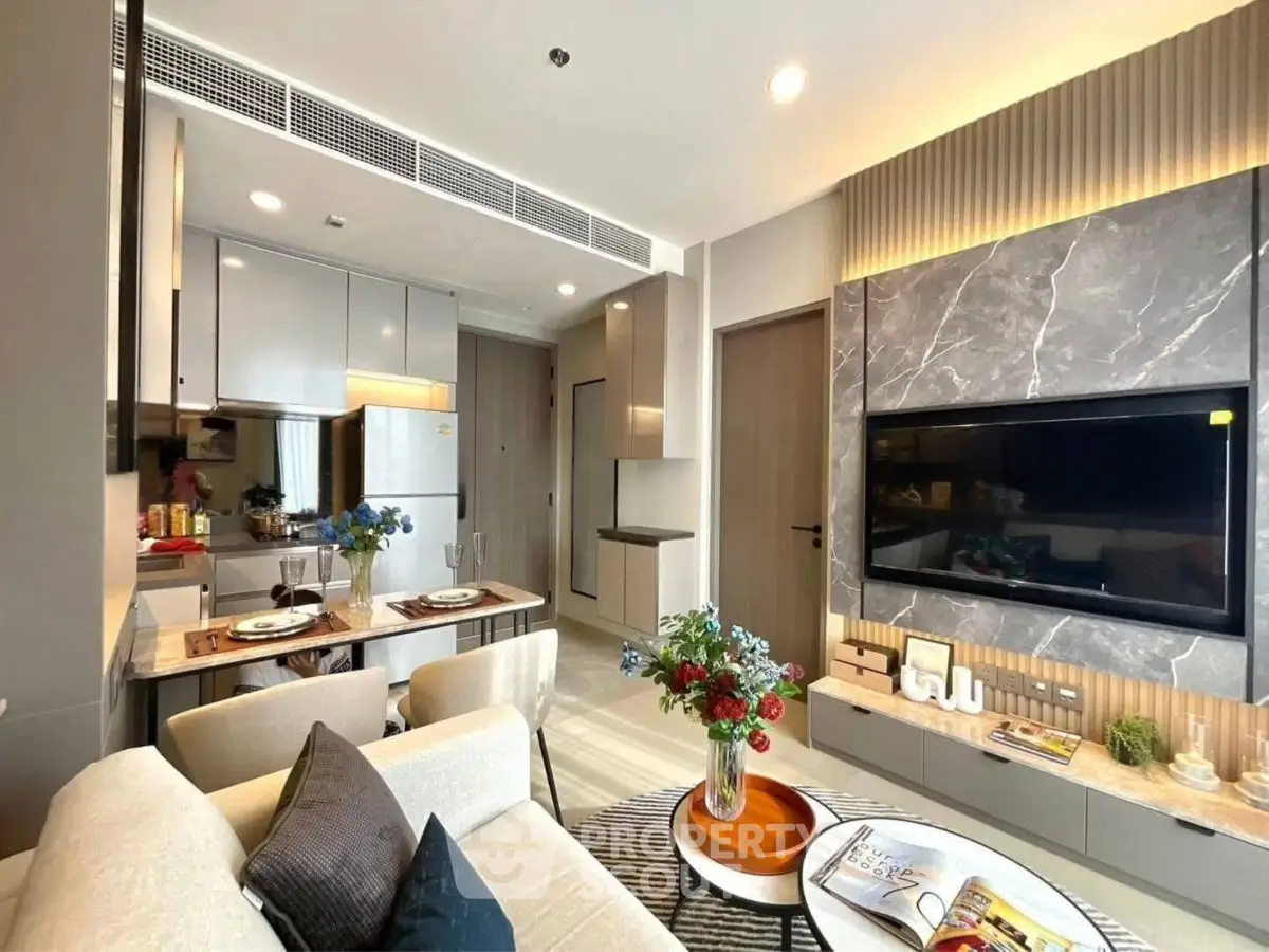 Modern living room with open kitchen, stylish decor, and cozy seating area.