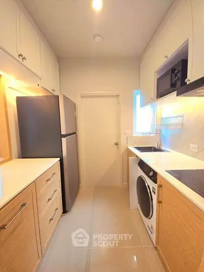 Modern kitchen with sleek appliances and ample storage in a cozy layout.