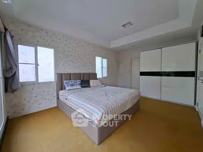 Spacious bedroom with stylish decor and large windows for natural light.