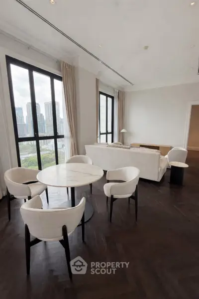 Luxurious living room with elegant furniture and stunning city view through large windows.