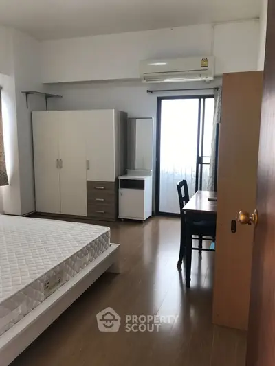 Spacious bedroom with modern furniture and balcony access in a stylish apartment.