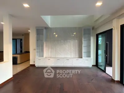 Spacious modern living room with hardwood floors and built-in shelving, perfect for stylish living.