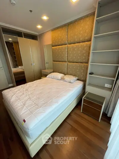 Modern bedroom with stylish headboard and built-in wardrobe in a cozy apartment.