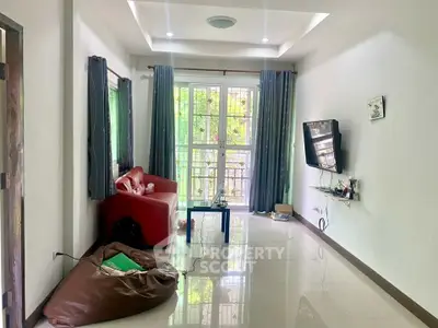 Spacious living room with modern decor and large window view.