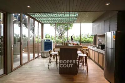 Modern kitchen with open layout and garden view, featuring sleek appliances and stylish bar seating.