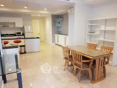 Spacious open-plan kitchen and dining area with modern furnishings and ample natural light.